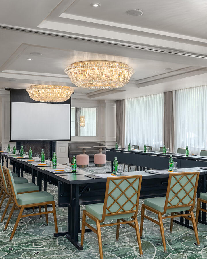 U-shaped table configuration for a meeting in the Foxhall room, highlighting two large round ceiling lights and spacious windows.