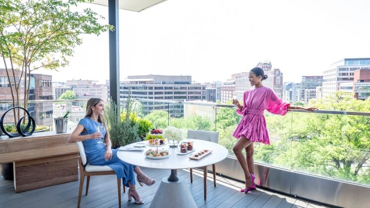 Two girls on a suite terrace overlooking the City