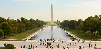 Visitors enjoying a sunny weekend in Washington, D.C., gathered around monument near popular tourist attractions.