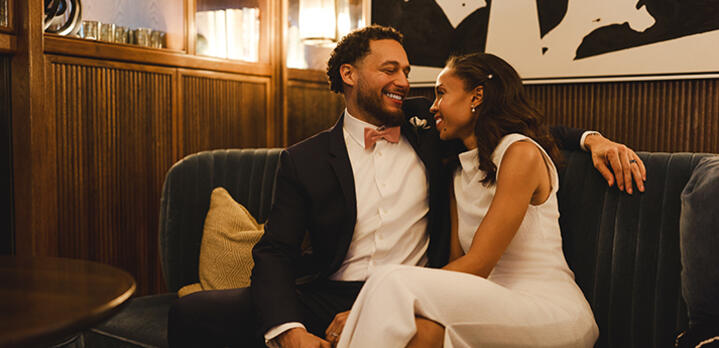 A newlywed couple smiling and celebrating their wedding at The Doyle bar within The Dupont Circle hotel.