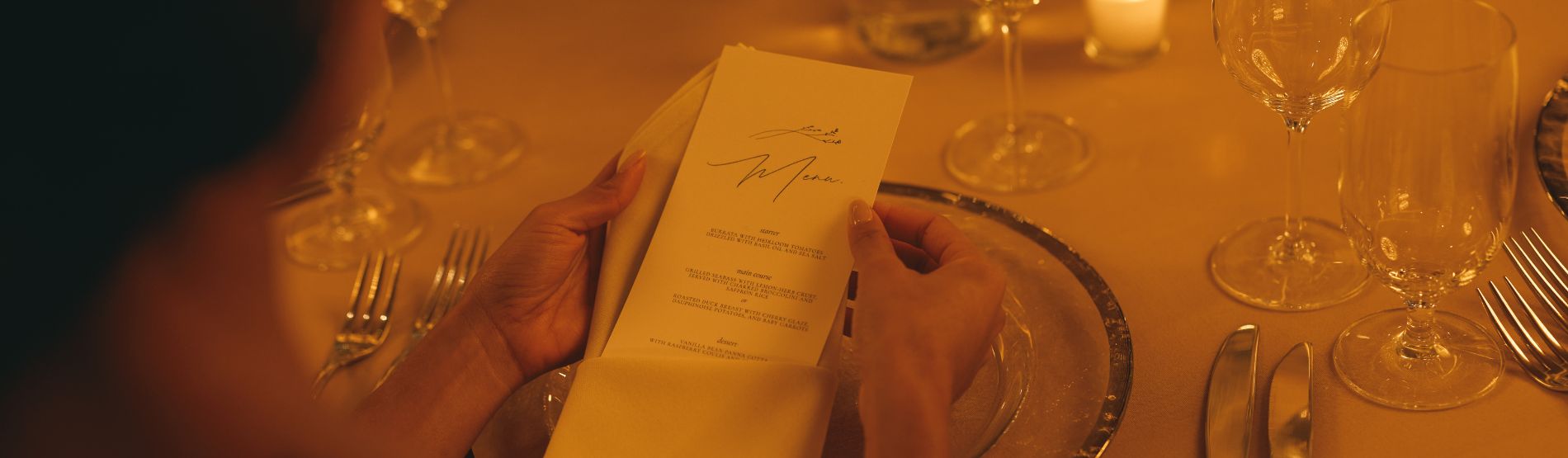Romantic wedding reception at The Dupont Circle: A guest looks over the menu at a stylishly set table under soft, dimmed lights.