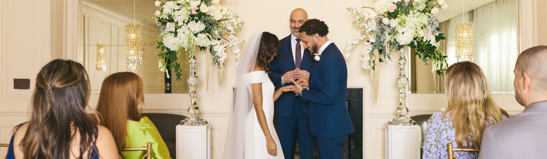 Wedding ceremony at The Dupont Circle Hotel with the bride and groom exchanging vows as guests look on