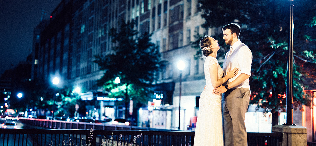 Bride and groom looking into each others eyes outside the hotel at night