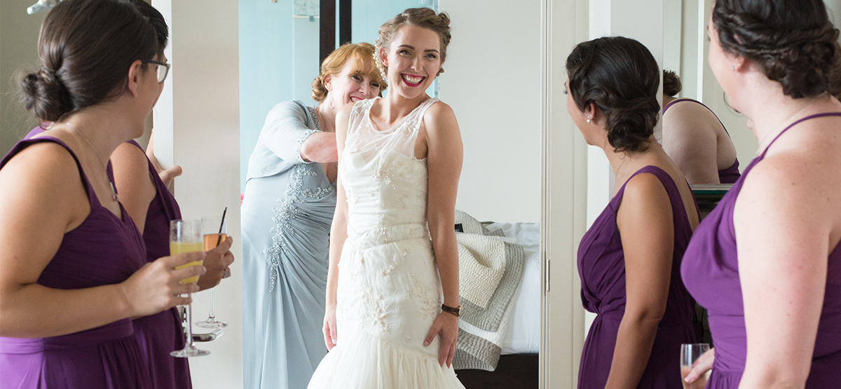 Bride getting ready with bridesmaids looking on