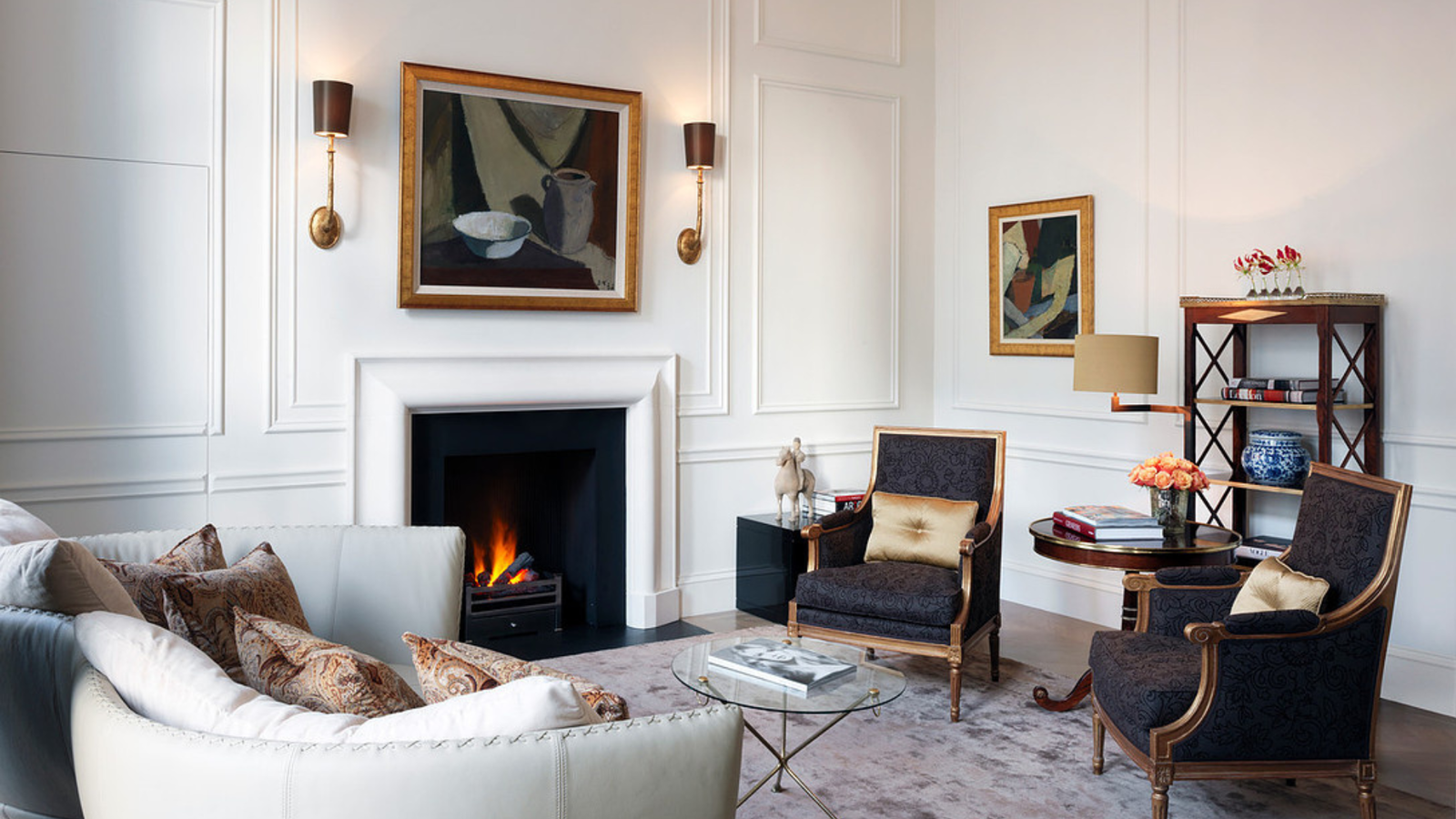 Interior of a suite living area at The Kensington Hotel with seating, decor, and a fireplace creating a cozy atmosphere