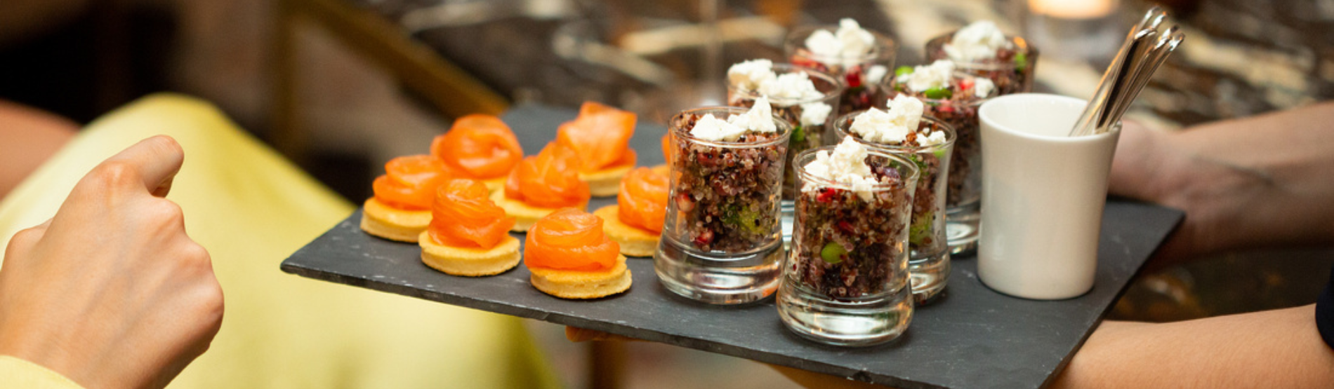 An inviting Town House setting for casual meetings, dining, and social gatherings, featuring a selection of finger foods with a hand reaching to pick one up