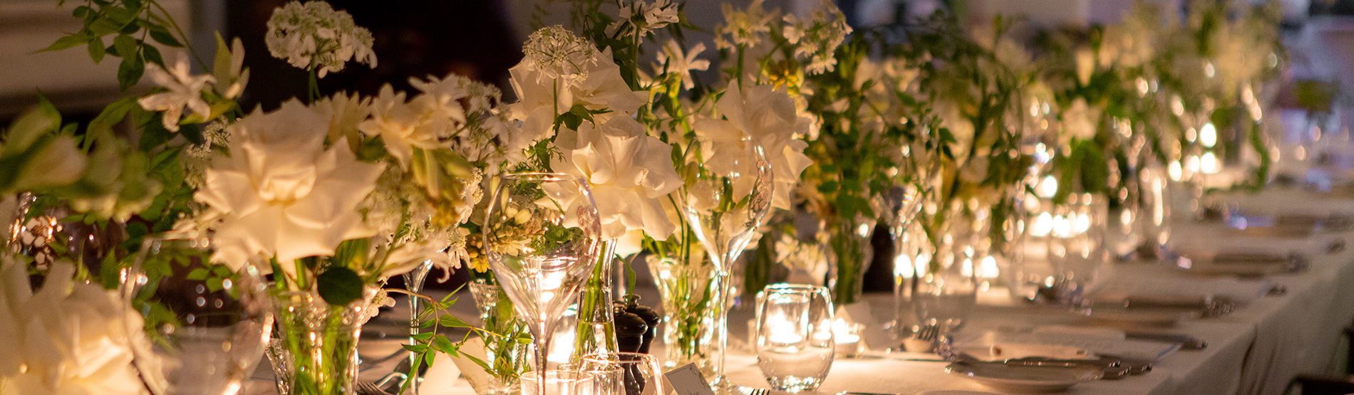Private dining setup at The Kensington Hotel, featuring a long table adorned with flowers and candles.