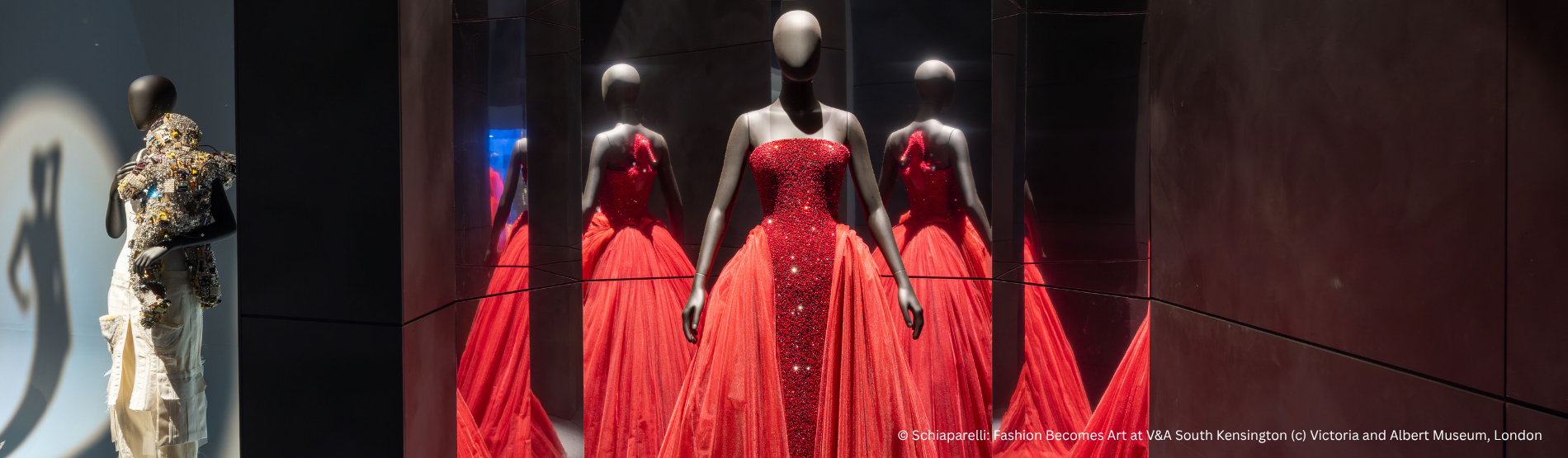 Reflections of elegance: A striking red ballroom dress at the V&A, captured through mirrors to showcase every angle of its design, from the structured side to the sweeping back