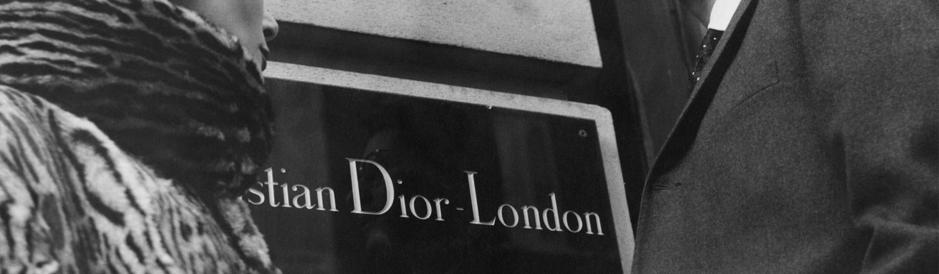 Shoppers looking at Christian Dior boutique sign