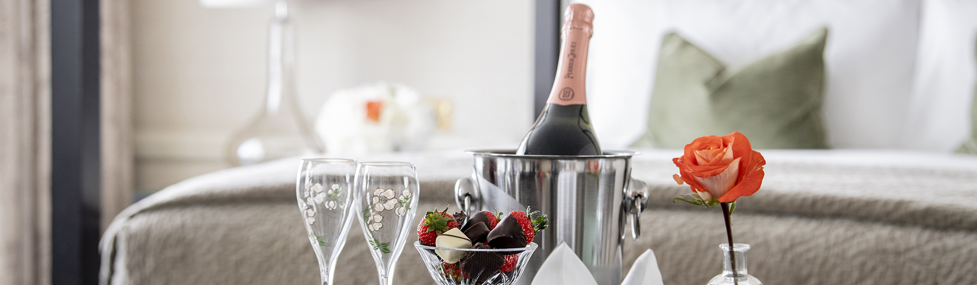 Bedroom with Champagne, chocolate covered strawberries and a rosed