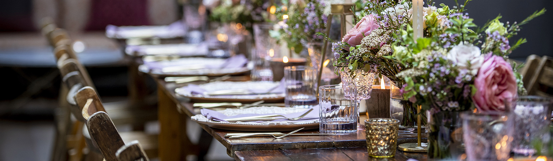 Private garden event at The Marylebone: an elegant long table setup featuring vibrant flowers with atmospheric candlelight.