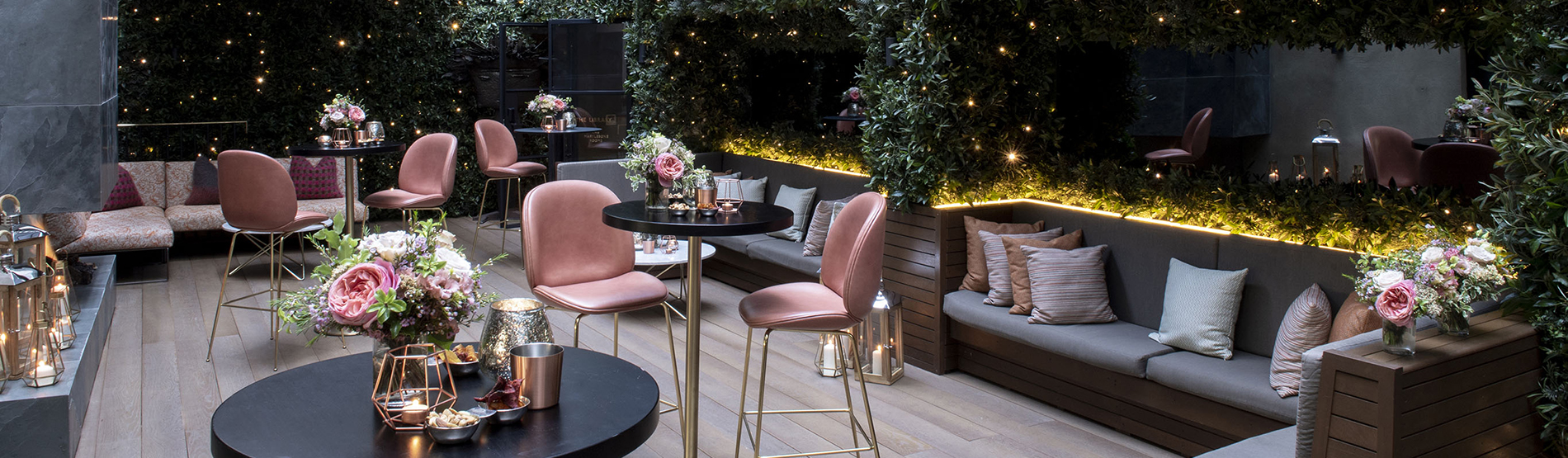 "Elegant high table setup at The Marylebone garden, featuring floral decor and candlelight for a private outdoor event.