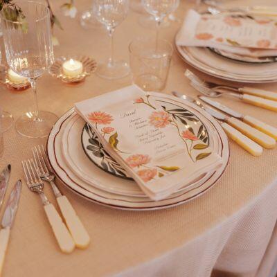 Elegant table setting in Queen Mary Hall prepared for a wedding, featuring neatly arranged place settings and refined décor.