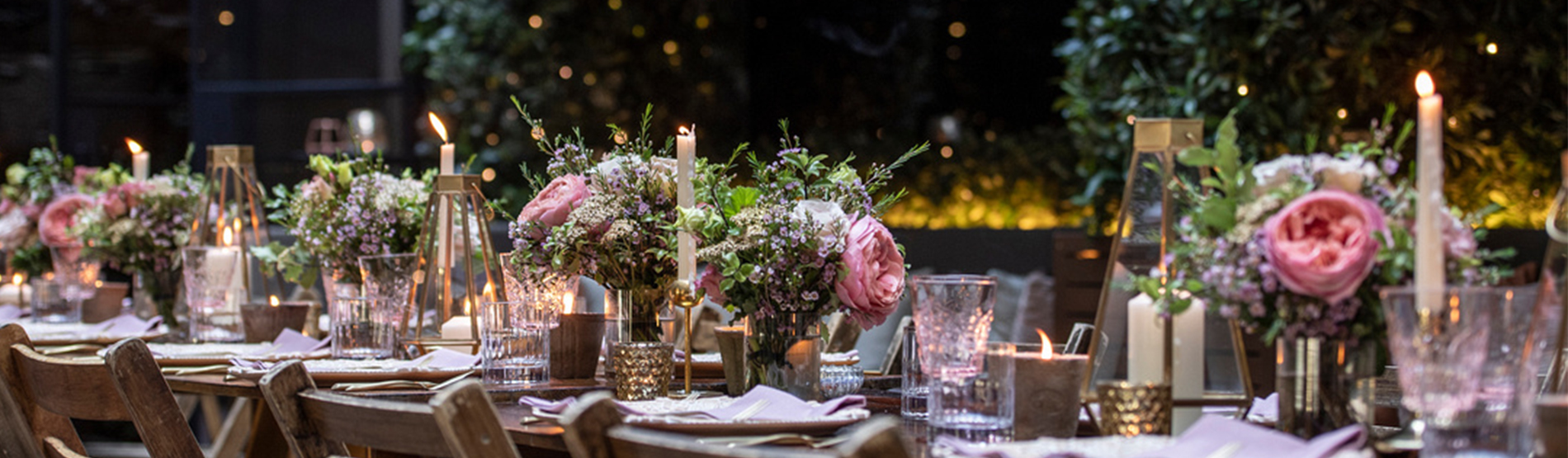 Long table with flowers, candles and crockery 
