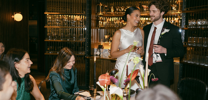 A bride in a white wedding gown and a groom in a suit celebrate their reception during an intimate wedding at The Marylebone.