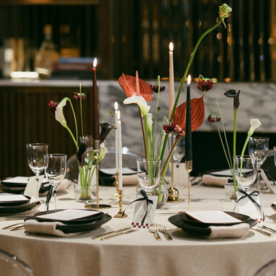 Beautifully set wedding tablescape at The Marylebone Hotel, featuring high candles, polished glassware, and moody, romantic lighting for a Central London reception.