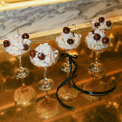 Individual wedding desserts topped with fresh cream and cherries, served in elegant espresso martini glasses at The Marylebone hotel