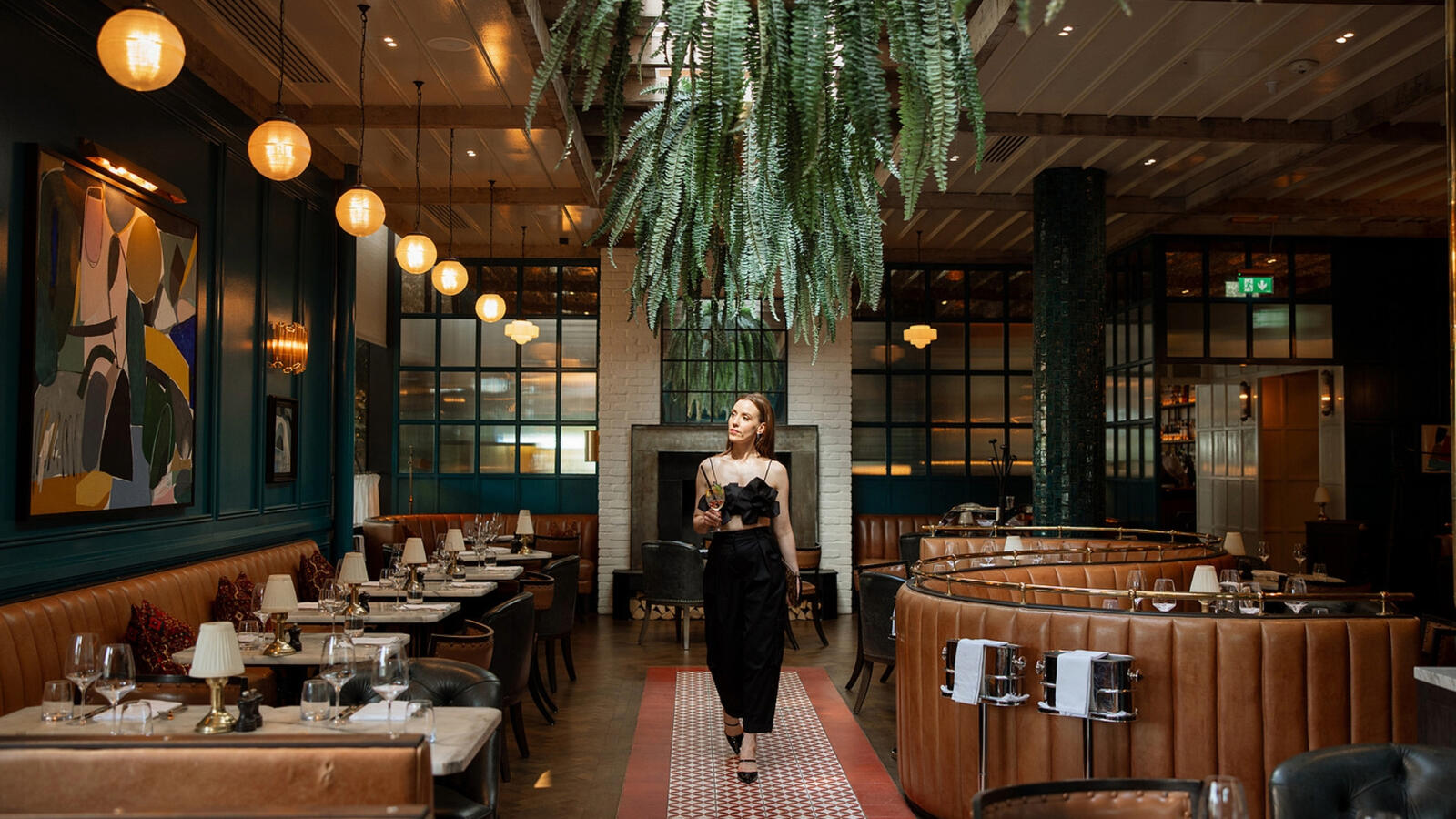 Louise O'Neill walking in the vibrant interior of The Grill Room restaurant during her curated weekend getaway at The River Lee in Cork.