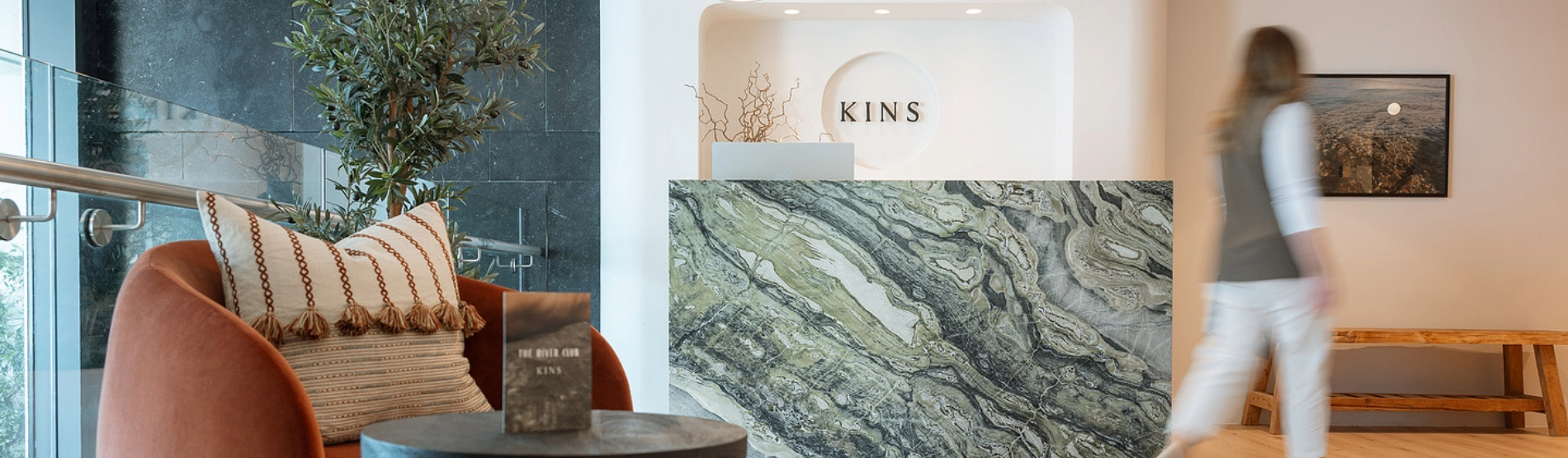 KINS advanced facial clinic reception at The River Lee Hotel, showing a luxurious waiting area and a guest arriving for a treatment.