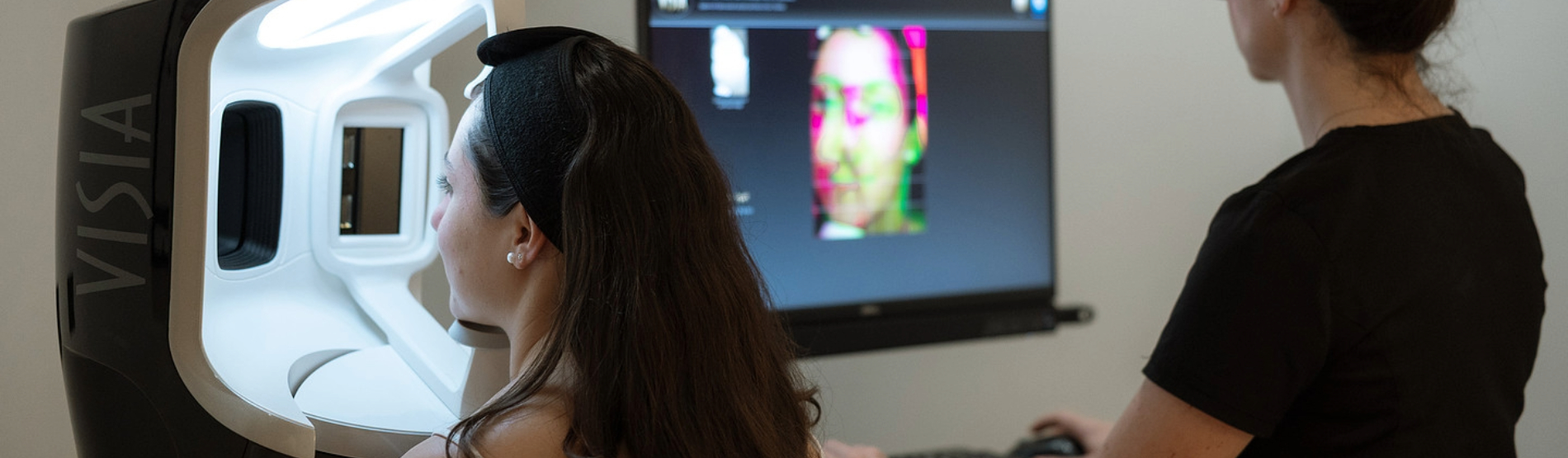 Patient undergoing a VISIA skin analysis with a KINS specialist for a personalized facial treatment consultation.
