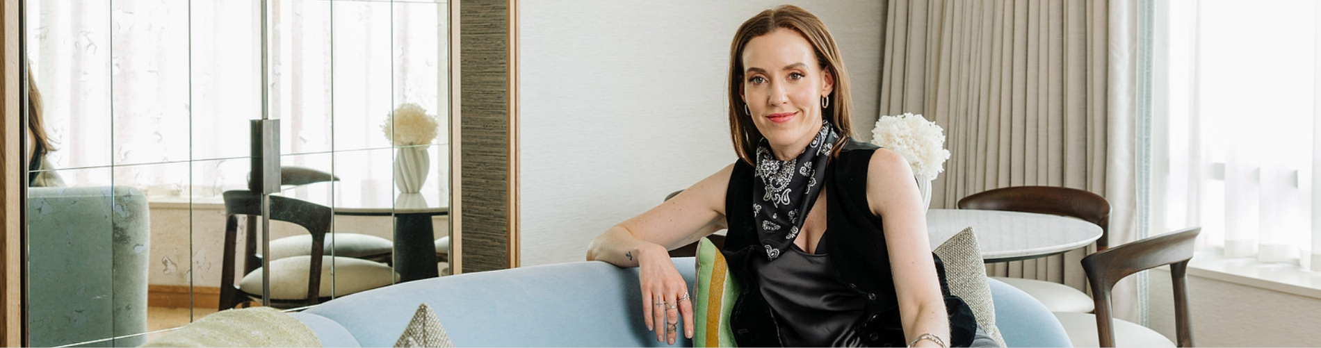 Author Louise O'Neill sitting on a light blue sofa inside a suite at The River Lee hotel in Cork.