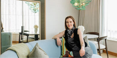 Author Louise O'Neill sitting on a light blue sofa inside a suite at The River Lee hotel in Cork.