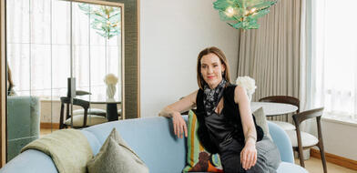 Author Louise O'Neill sitting on a light blue sofa inside a suite at The River Lee hotel in Cork.