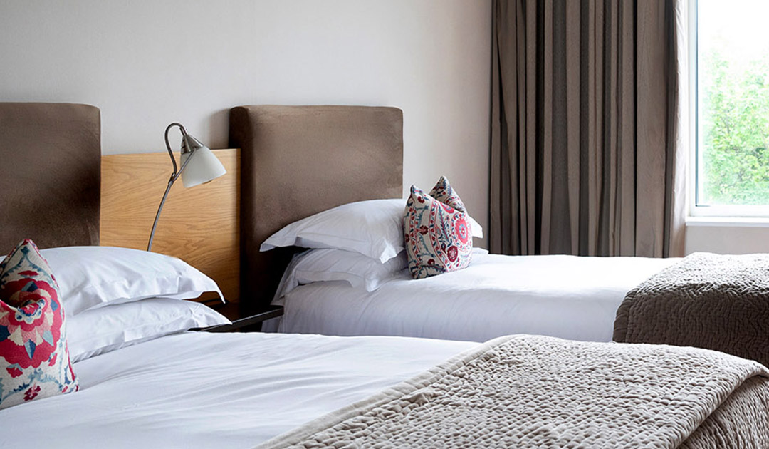 The Classic Double Room with River View at The River Lee Hotel in Cork, providing a comfortable stay with two double beds and stunning views of the river.