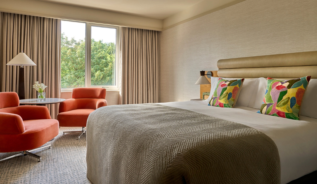 A perfect blend of comfort and style, the Classic Room at The River Lee in Cork offers a cozy double bed, a small table, a reading lamp, and two distinctive orange armchairs