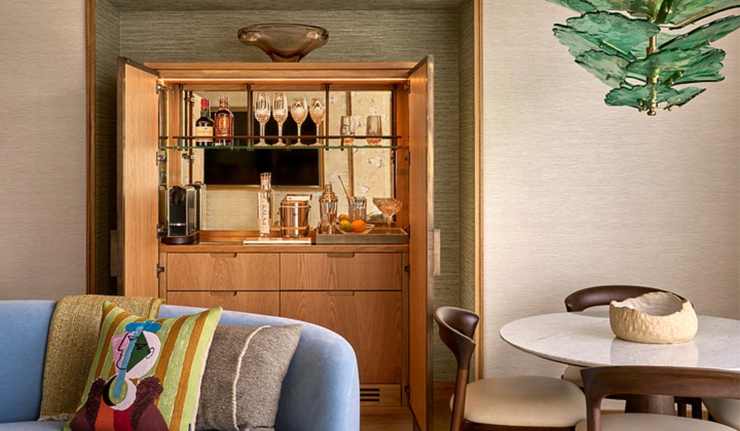 Modern luxury suite living room at The River Lee Hotel, showing a sofa, private bar area, and a styled 4-seater dining table.