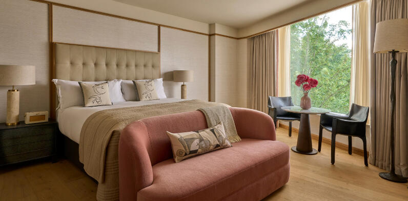 King bed and peach sofa inside a luxury suite at The River Lee Hotel.