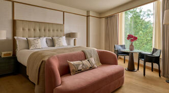 King bed and peach sofa inside a luxury suite at The River Lee Hotel.