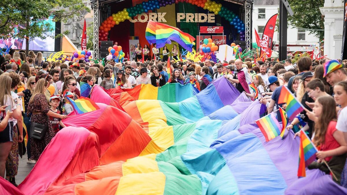 Parade goers hold a large Pride flag