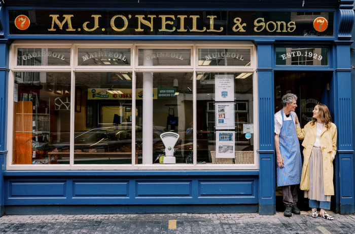 Louise stands outside M.J. O'Neill & Sons, chatting and smiling in front of her family's butcher shop, which has been a fixture on the main street since 1919.