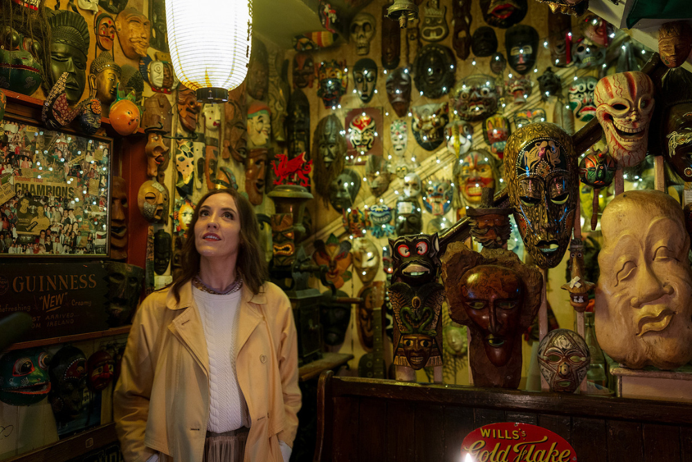 Louise sits in a Cork pub, gazing at the iconic walls lined with posters and memorabilia, soaking in the atmosphere.
