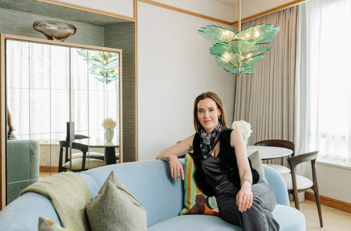 Curator Louise O'Neill sits on a light blue sofa inside a hotel suite at The River Lee,for a West Cork-inspired experience.