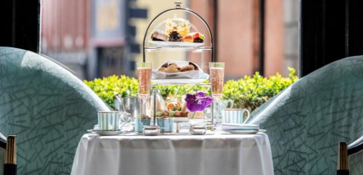 Elegant afternoon tea experience at The Gallery, showcasing a tiered display of handcrafted pastries and savory sandwiches within the luxurious surroundings of The Westbury Hotel.