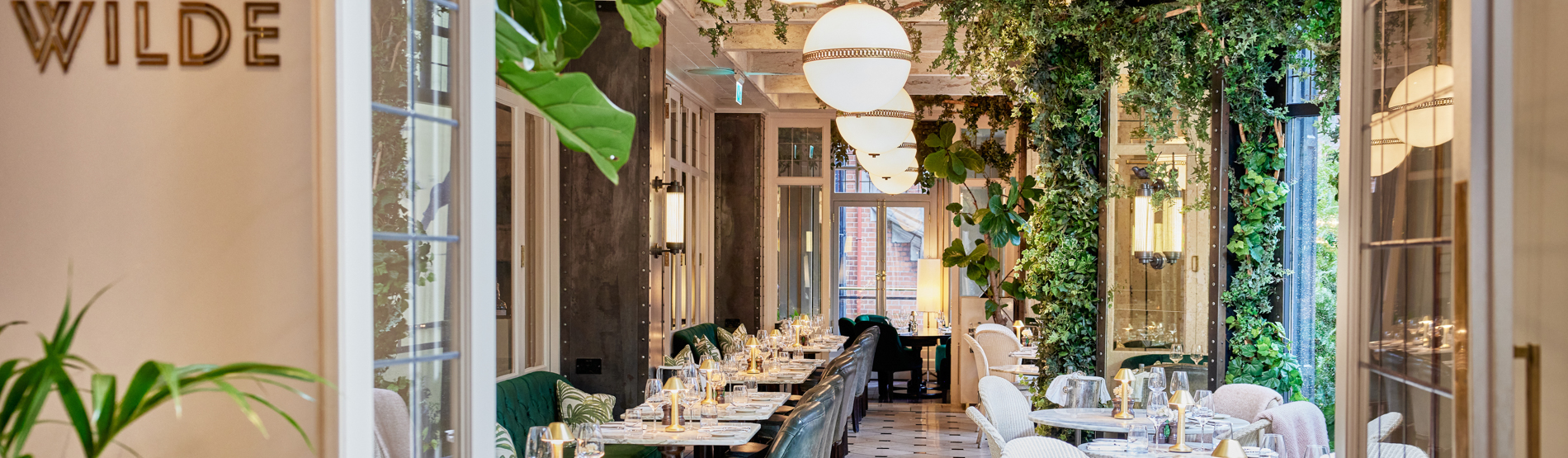 View of WILDE restaurant with elegantly arranged tables prepared for guests to enjoy an exquisite dining experience.