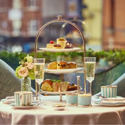 Luxury afternoon tea at The Westbury: The artisanal dessert from a tiered stand alongside sparkling champagne and traditional tea service.