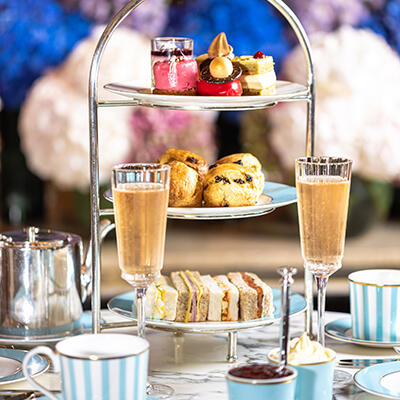 Elegant afternoon tea setting at The Galery, with two champagne flute and a tiered stand filled with various pastries and sandwiches.