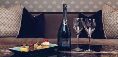 Bottle of Charles Heidsieck Champagne with glasses and plate of pastries