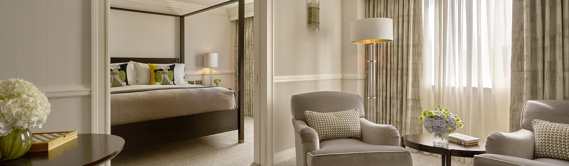 Luxurious suite at The Westbury hotel, featuring a four-poster bed and the living aread in the room before 