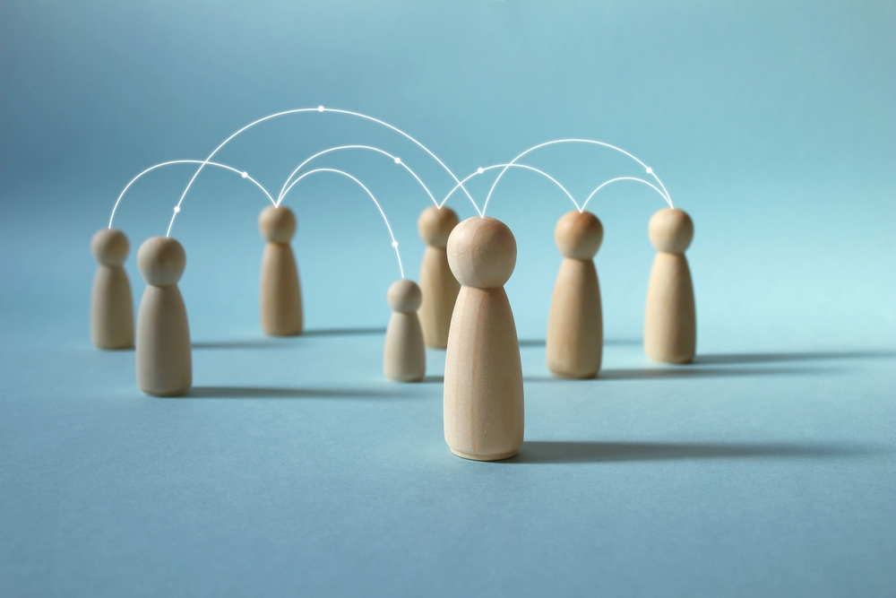 Image from Shutterstock, credit parkjihee, asset id 2596351957. A business image of wooden carved dolls communicating while being connected in a network from their respective positions.