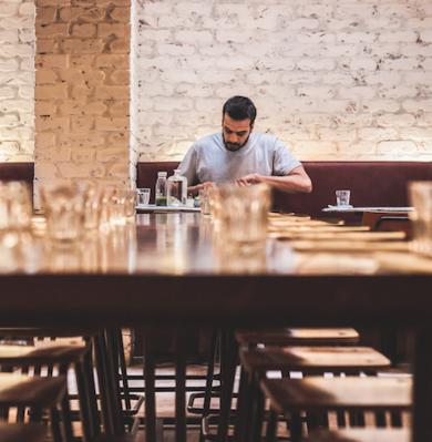 man eating alone at a long table