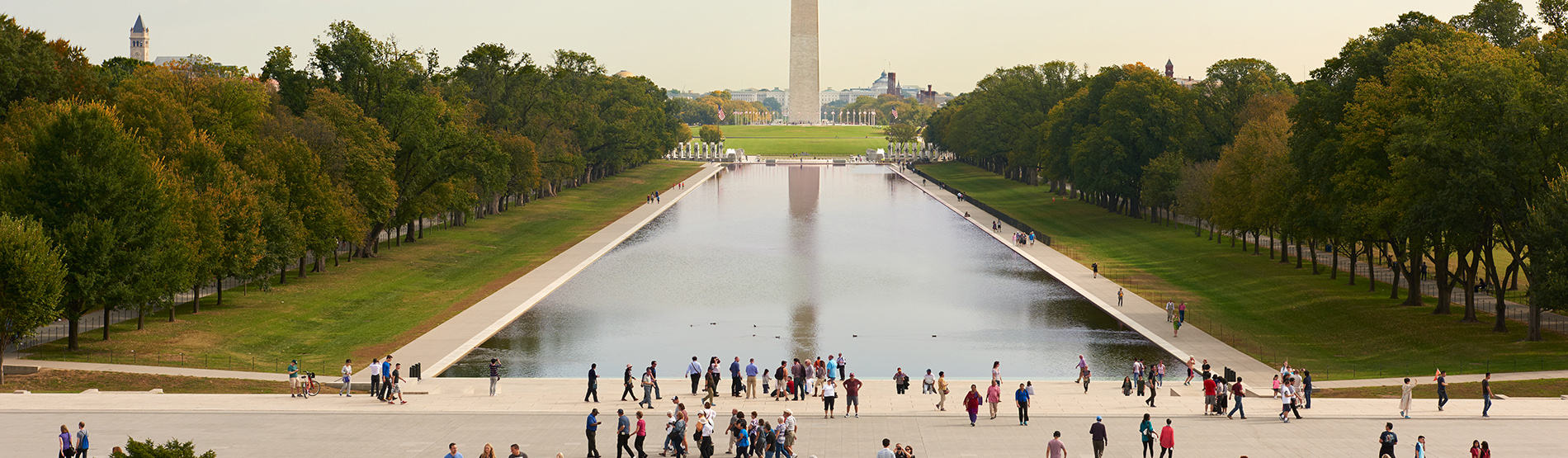 Visitors enjoying a sunny weekend in Washington, D.C., gathered around monument near popular tourist attractions.