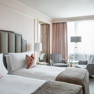 The Westbury Twin 2 Single Beds with crisp white sheets and colorful pillows, neatly arranged in a classic room at the Westbury Hotel.