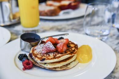 plate with pancakes and fresh fruit with syrup